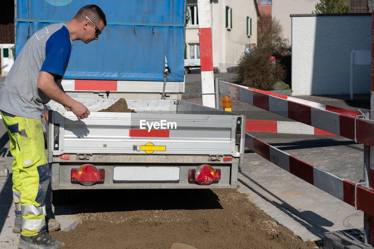 Side view of worker working at road