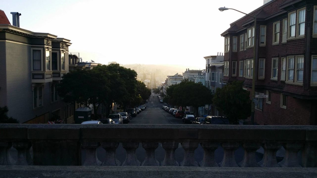Road amidst buildings against clear sky