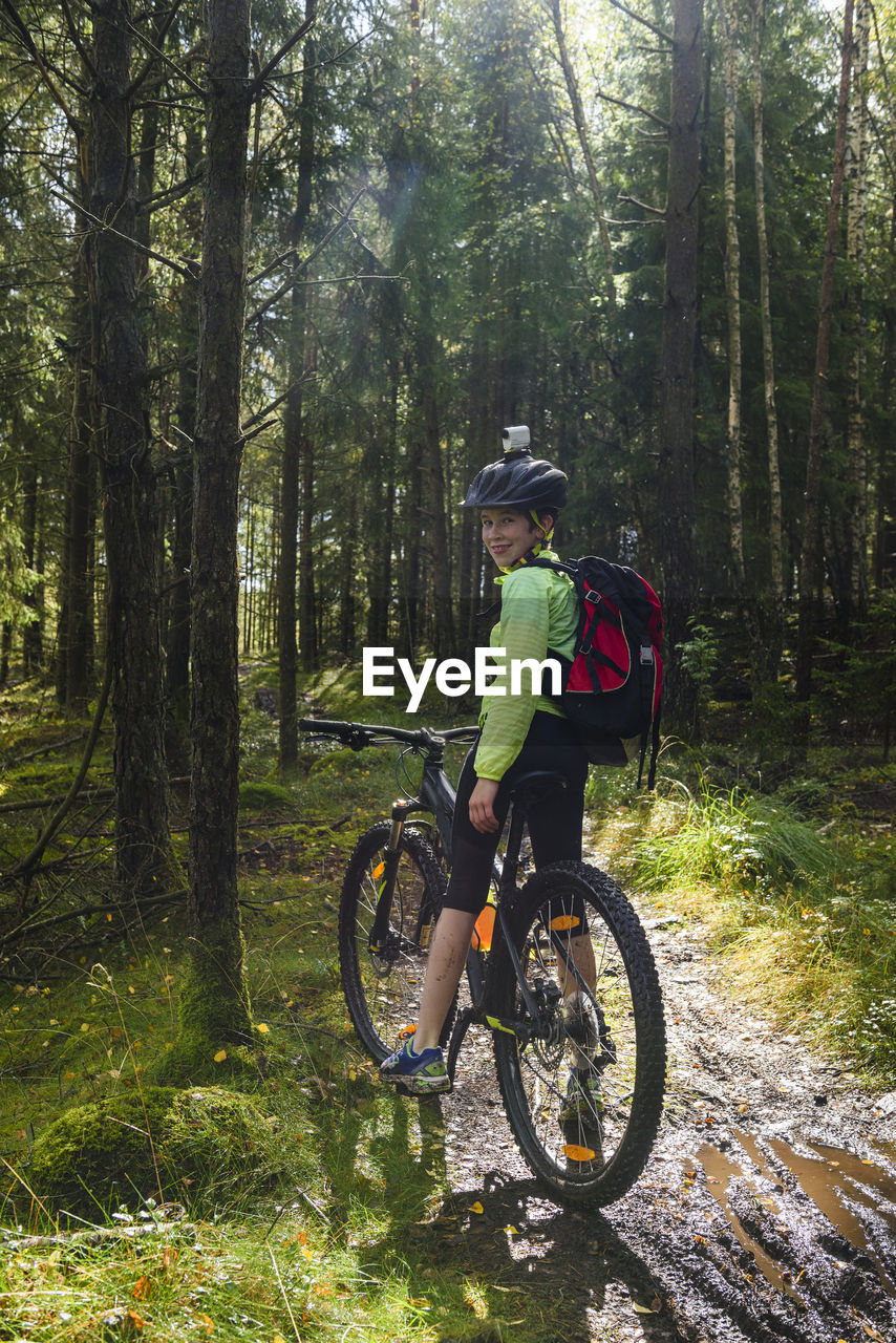 Boy cycling in forest