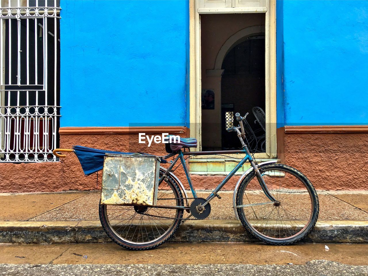 BICYCLE PARKED AGAINST BLUE WALL
