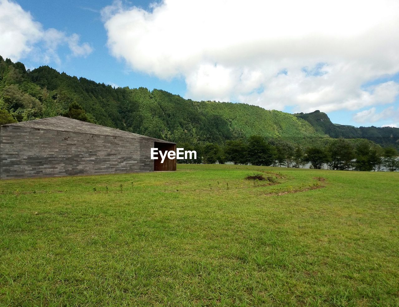 Scenic view of grassy field against cloudy sky