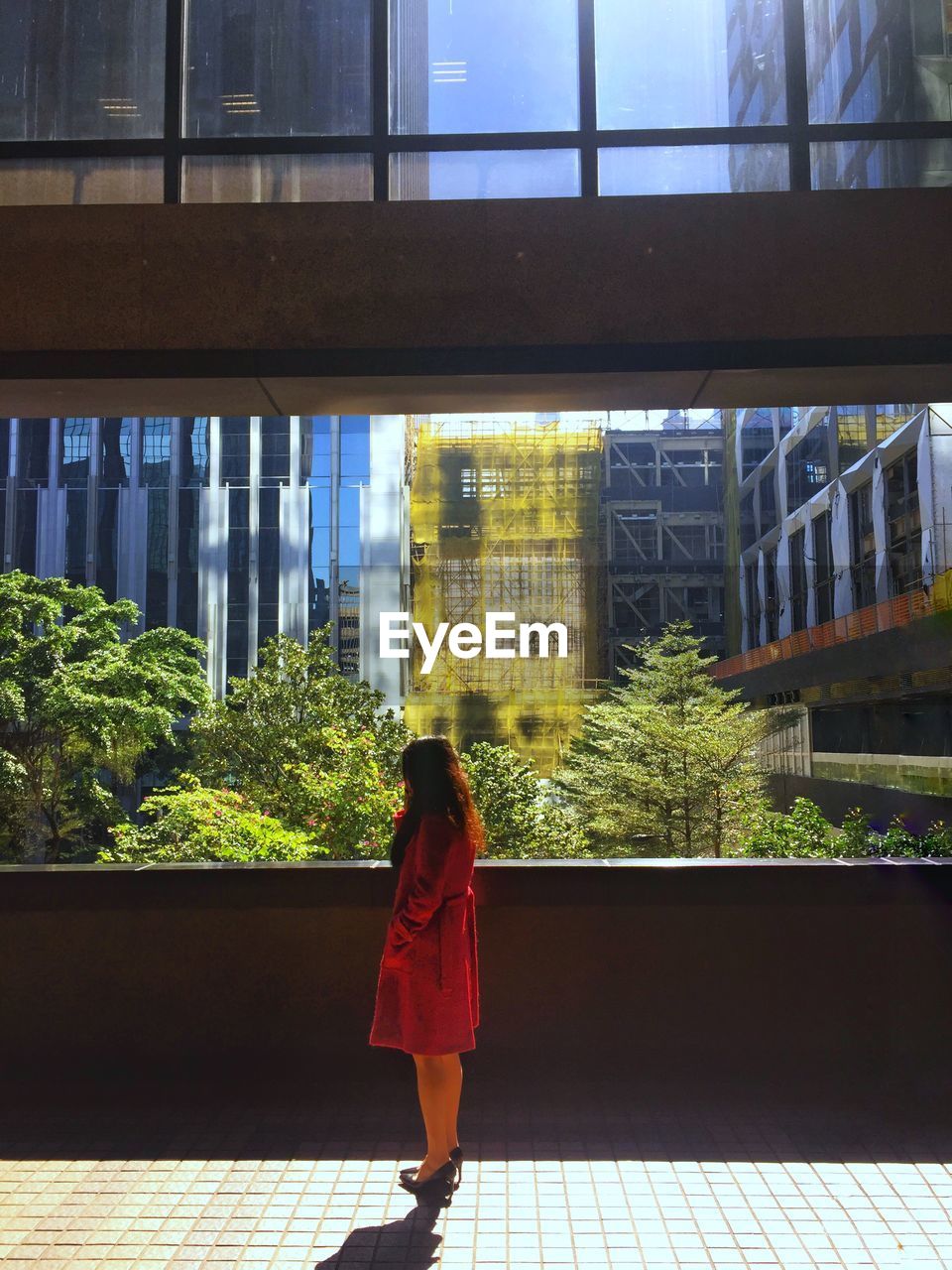 FULL LENGTH REAR VIEW OF WOMAN WALKING AGAINST BUILDING