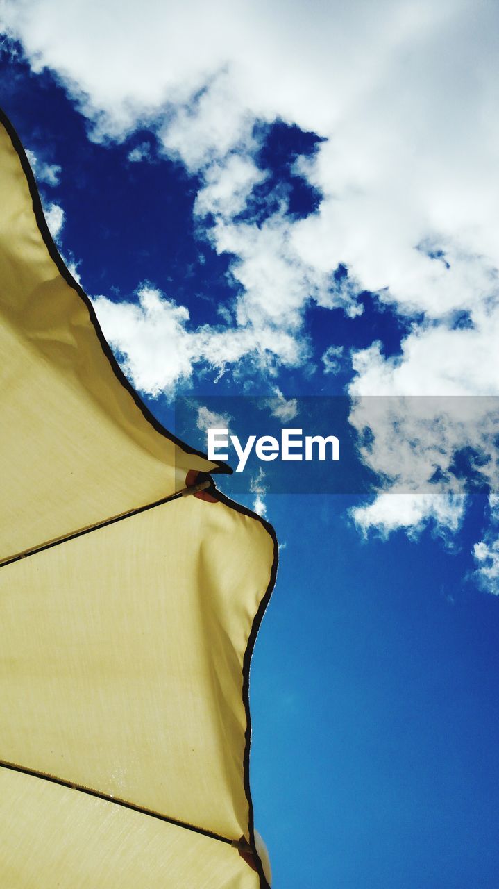 LOW ANGLE VIEW OF SUNSHADE AGAINST BLUE SKY