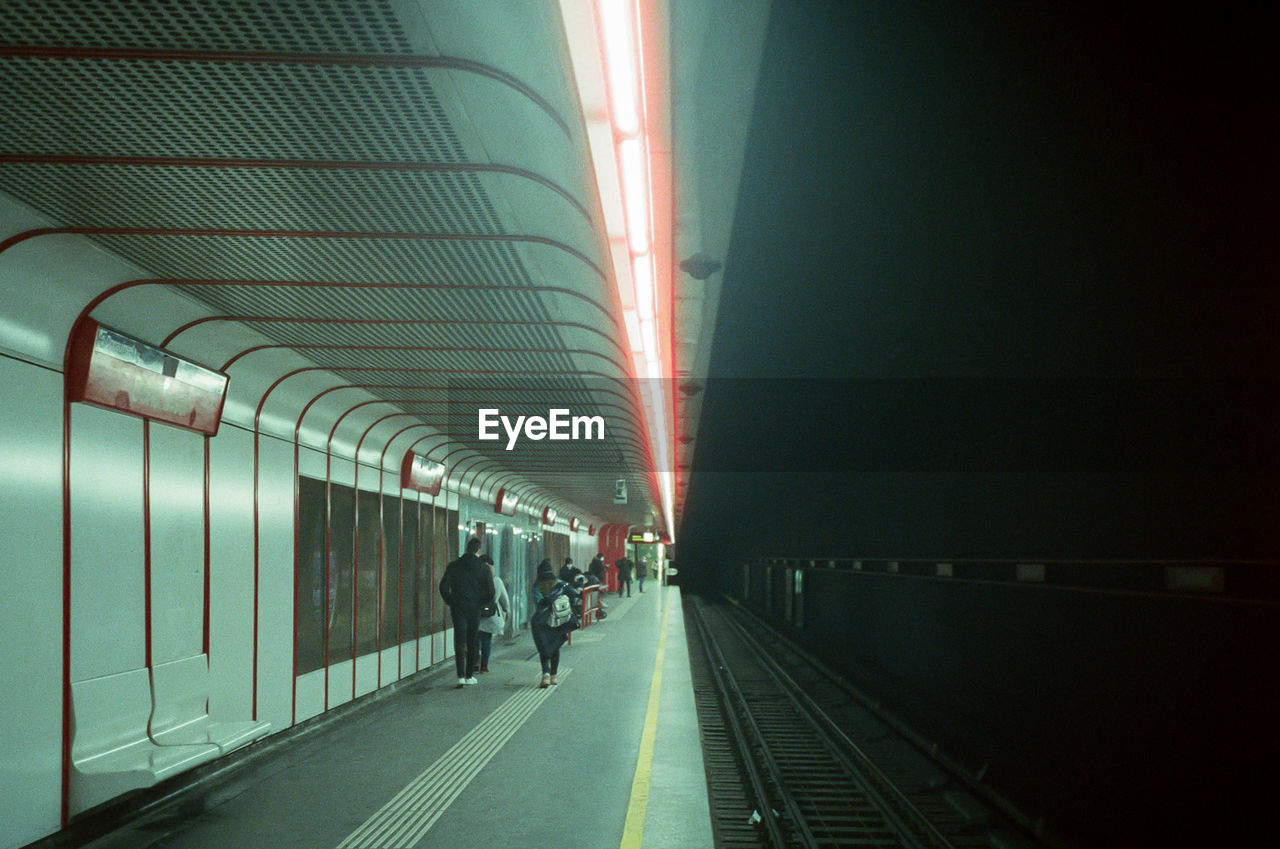 People in illuminated railroad station at night