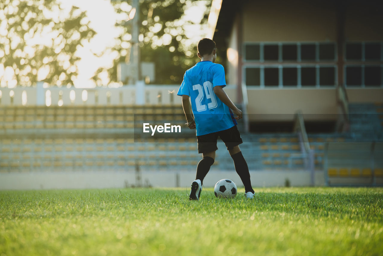 FULL LENGTH OF MAN PLAYING SOCCER BALL