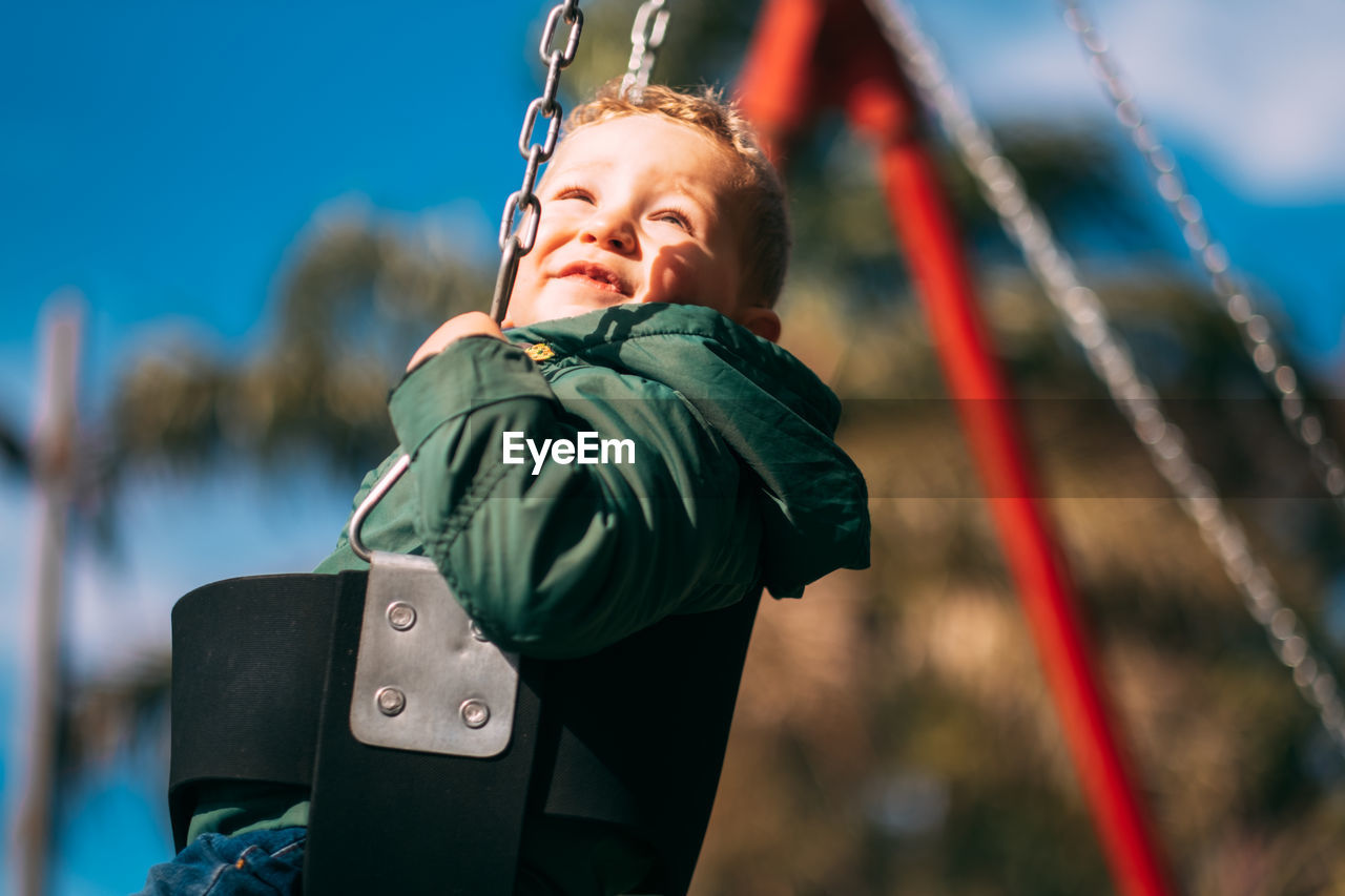 Portrait of little boy swinging