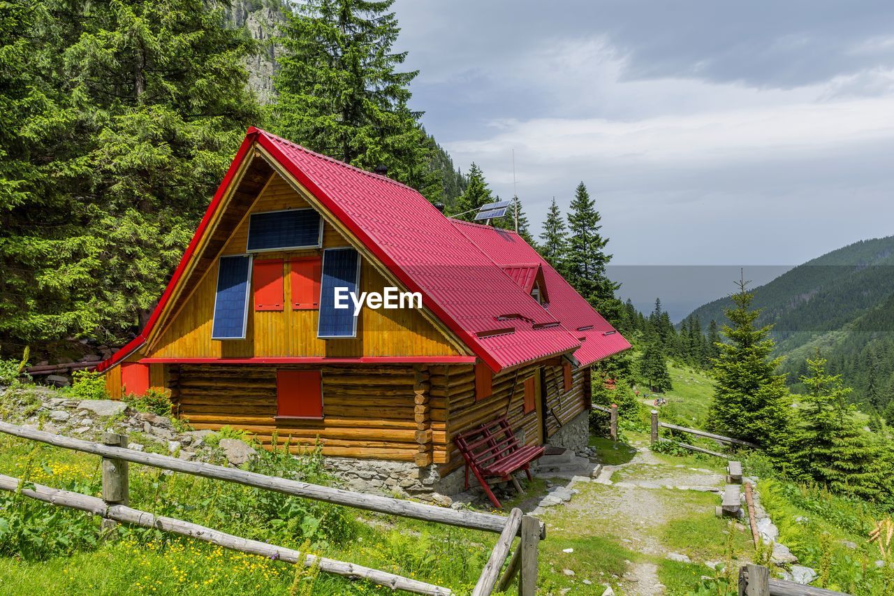 BUILT STRUCTURE AGAINST TREES AND MOUNTAINS