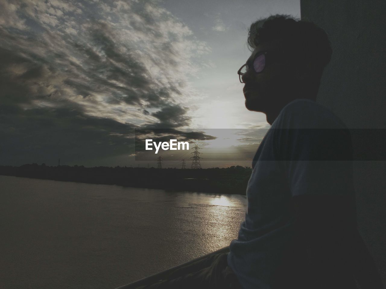 Man looking at sea against sky during sunset