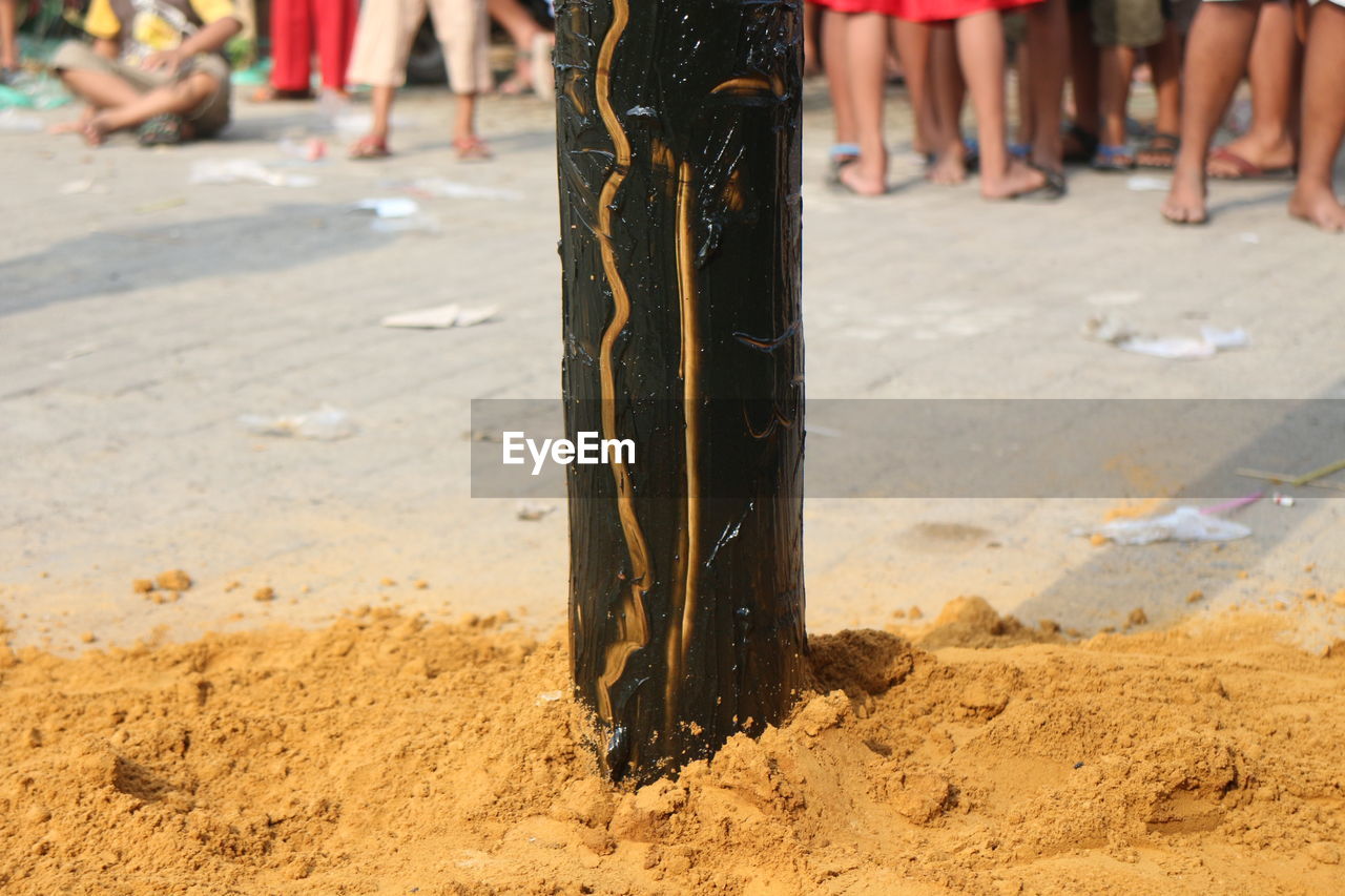 LOW SECTION OF WOMAN STANDING ON SAND