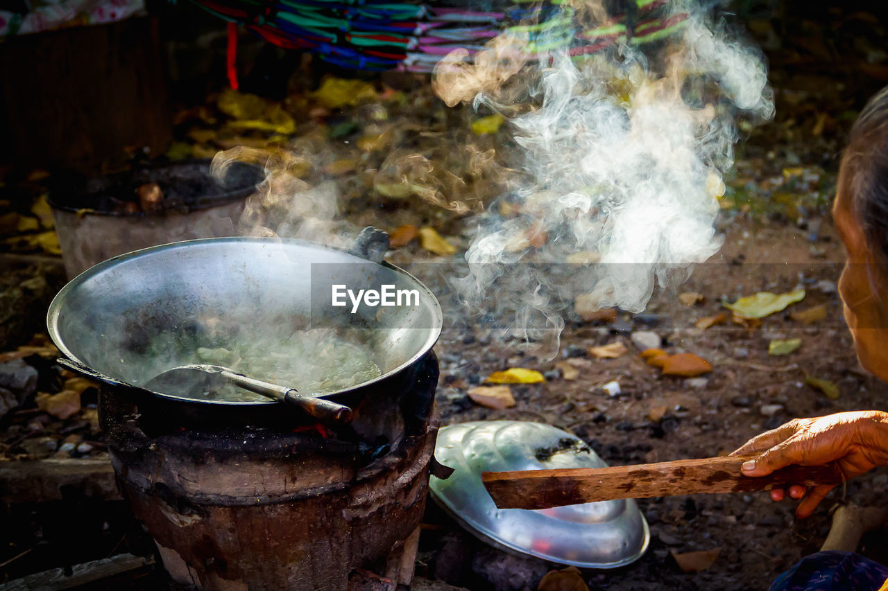 Side view of woman preparing food in yard