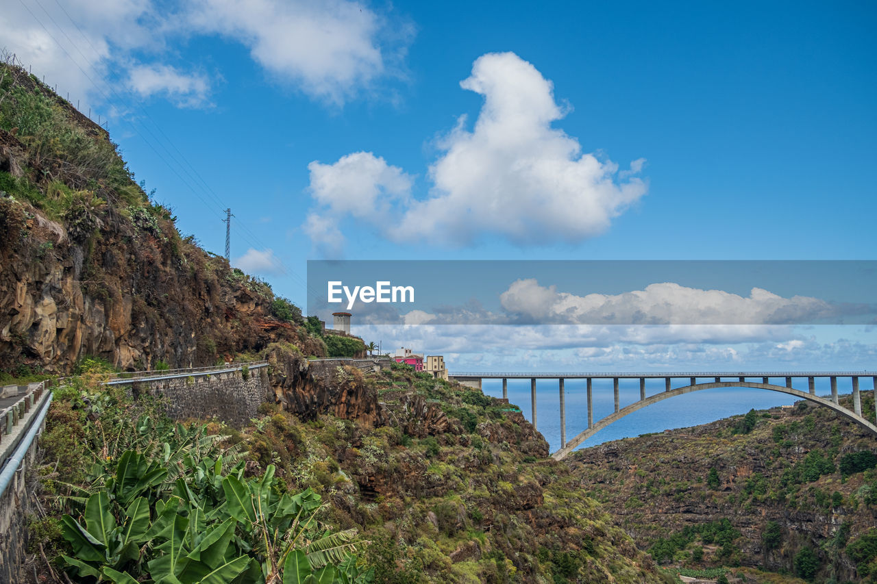 sky, cloud, water, nature, architecture, bridge, travel destinations, travel, built structure, environment, transportation, coast, sea, scenics - nature, land, landscape, tourism, plant, blue, no people, mountain, beauty in nature, vacation, outdoors, beach, day, tree, city, holiday, trip, tranquility, reservoir, tranquil scene, coastline