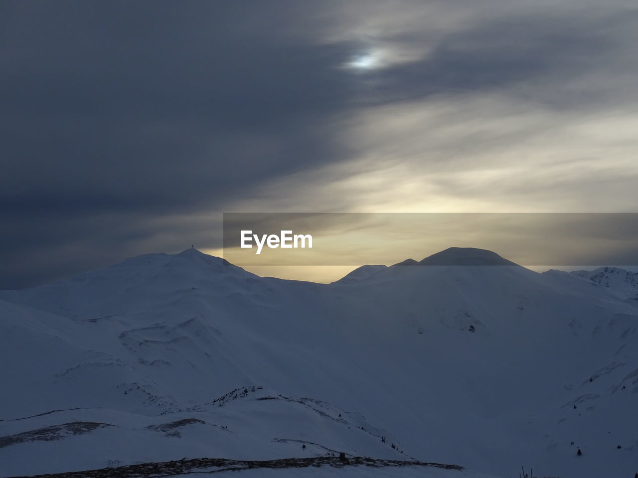 SCENIC VIEW OF SNOW COVERED MOUNTAINS AGAINST SKY AT SUNSET