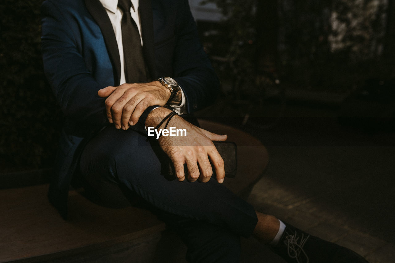 Low section of businessman sitting outdoors