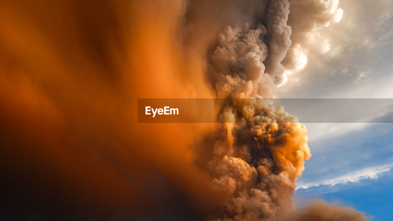 Smoke emitting from volcanic mountain against sky 