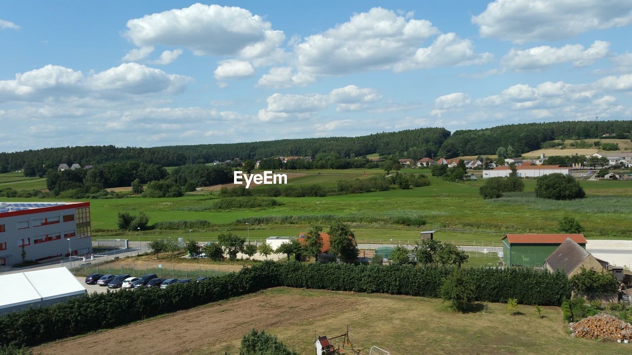 HIGH ANGLE VIEW OF HOUSES AND TREES ON LANDSCAPE AGAINST SKY