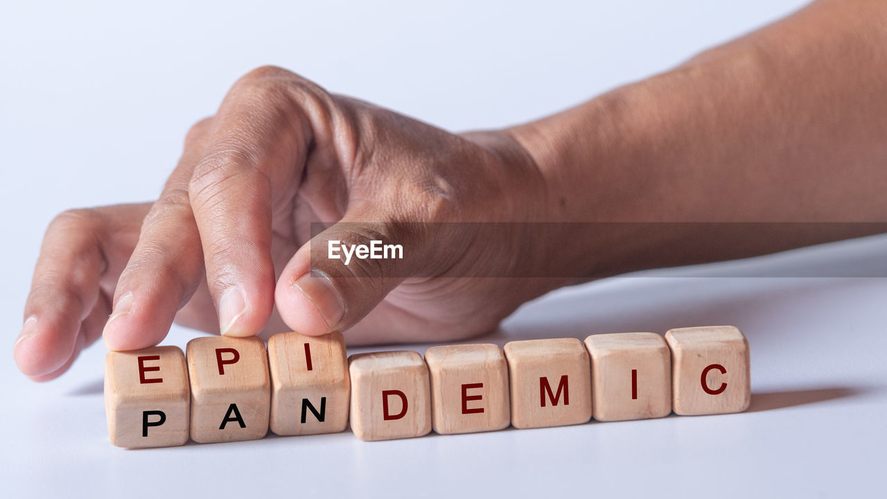 hand, text, studio shot, indoors, finger, close-up, western script, one person, adult, business, communication, alphabet, letter, men, wood, number