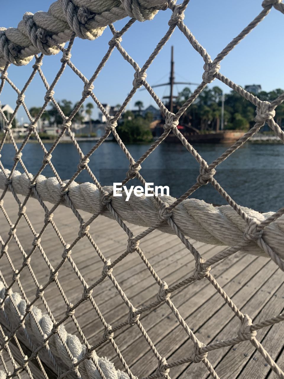 CLOSE-UP OF ROPE AGAINST FENCE