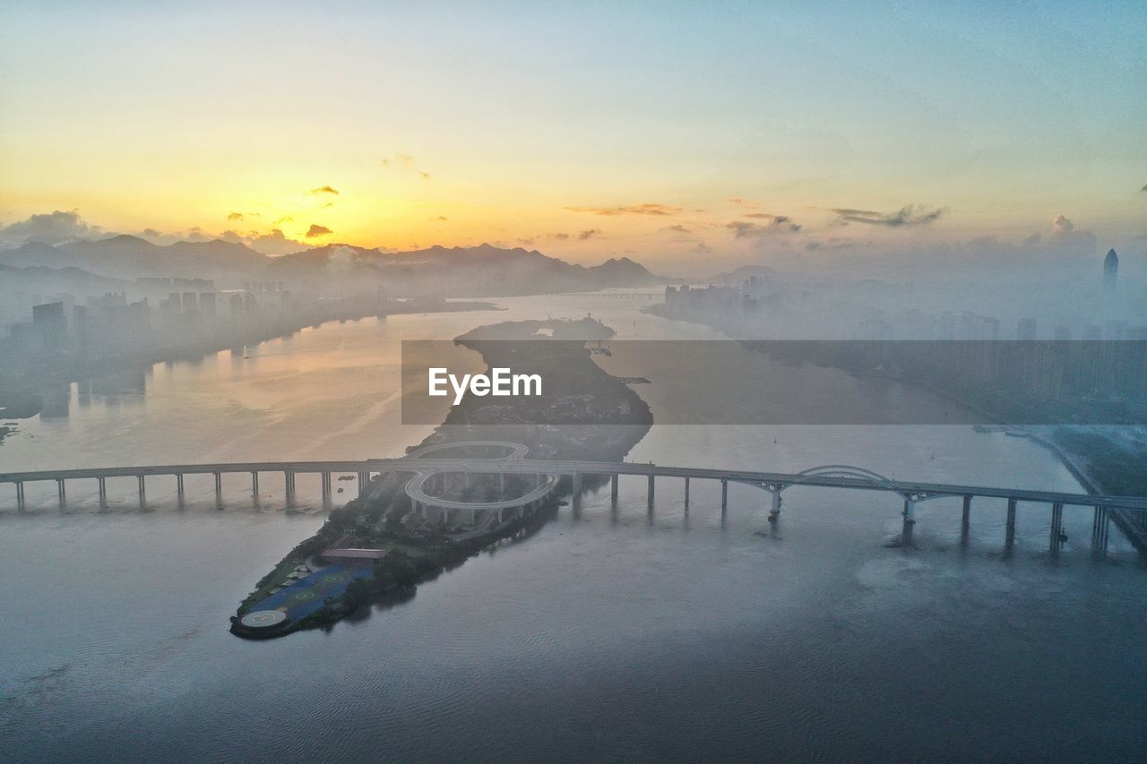 morning, dawn, sunrise, sky, water, fog, environment, nature, scenics - nature, reflection, beauty in nature, landscape, sea, tranquility, architecture, cold temperature, horizon, travel destinations, snow, mist, travel, cloud, sun, no people, winter, mountain, outdoors, tranquil scene, ice, built structure, twilight, wave, transportation, land, ocean, city, tourism