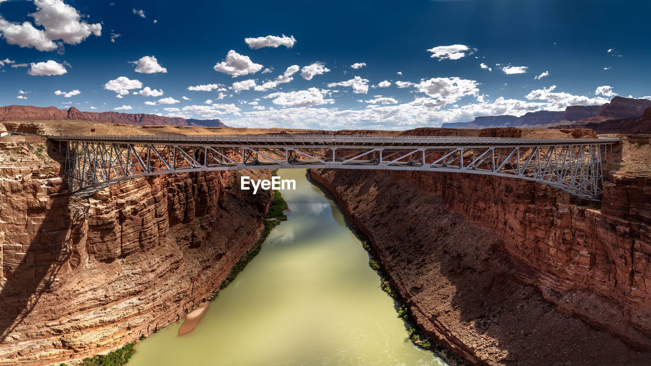 Navajo bridge over river against sky