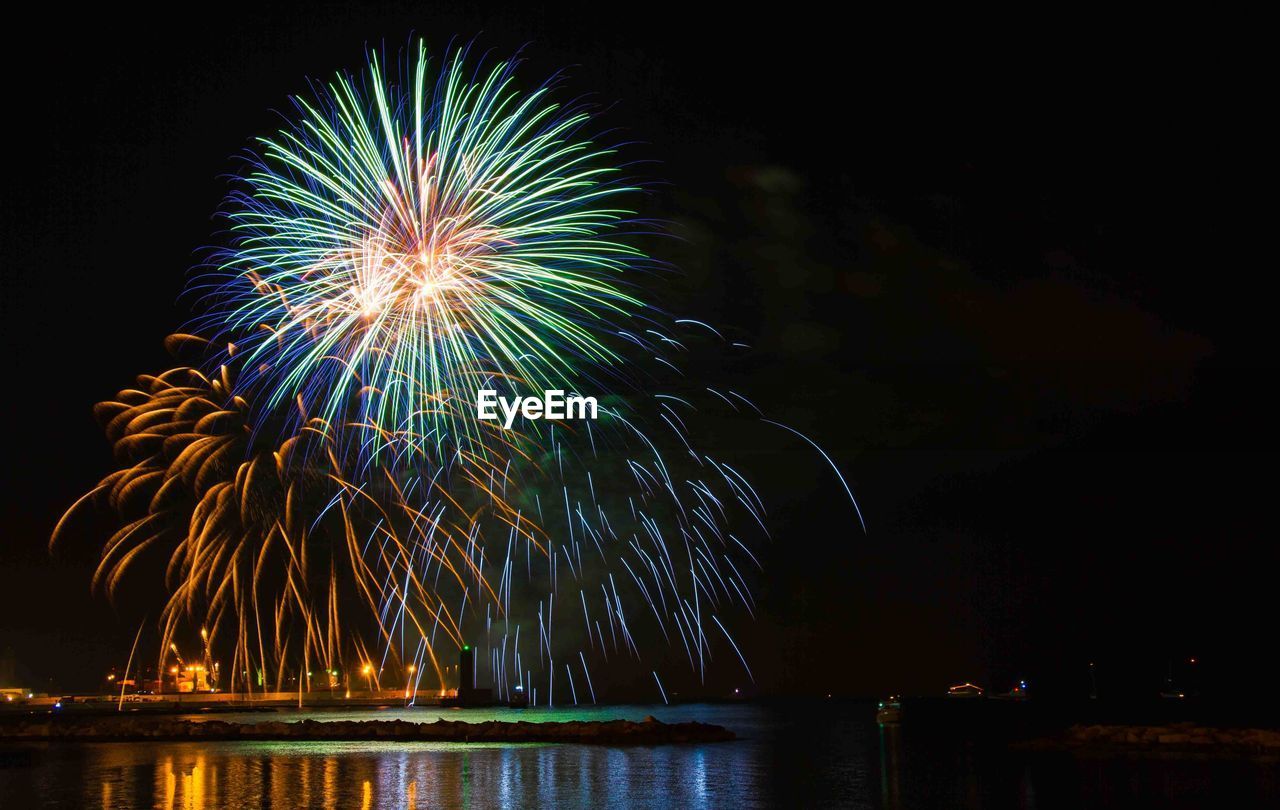 Low angle view of firework display at night