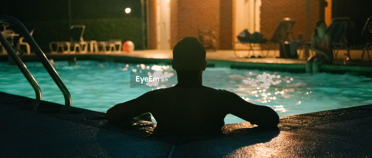Rear view of man in swimming pool