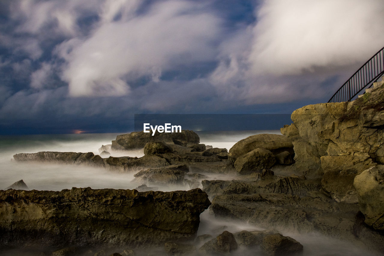 Rock formations in sea against sky