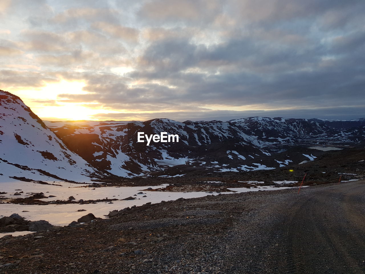 SNOW COVERED LANDSCAPE AGAINST SKY DURING SUNSET