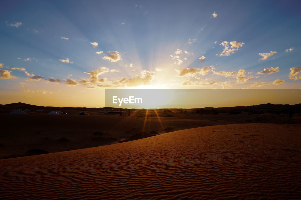 Scenic view of desert against sky during sunset