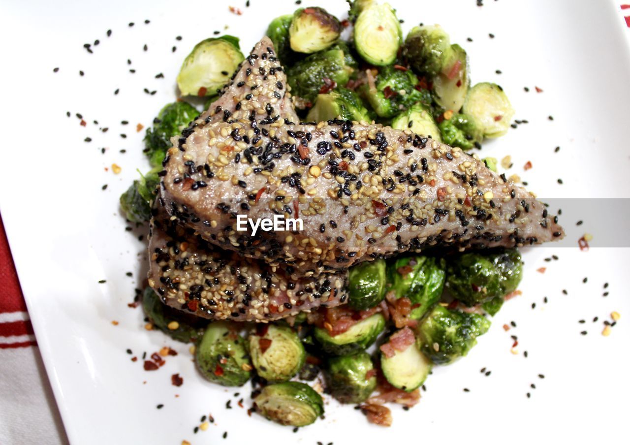 High angle view of tuna and brussels sprouts served in plate