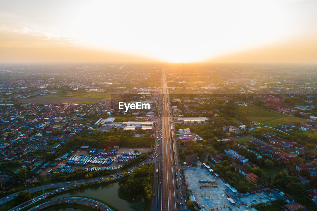 High angle view of illuminated city buildings against sky during sunset