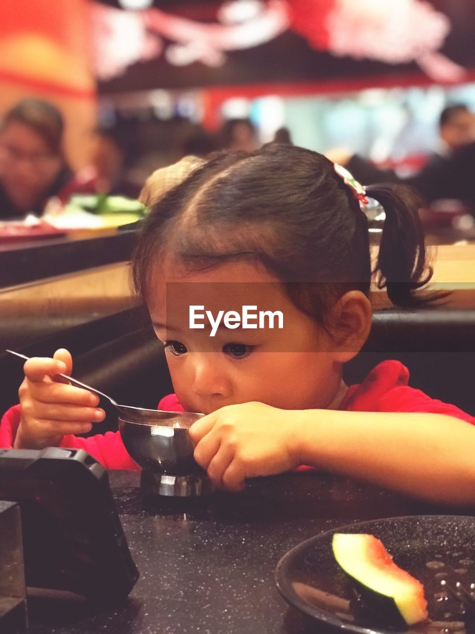 Close-up of girl having food at table in restaurant