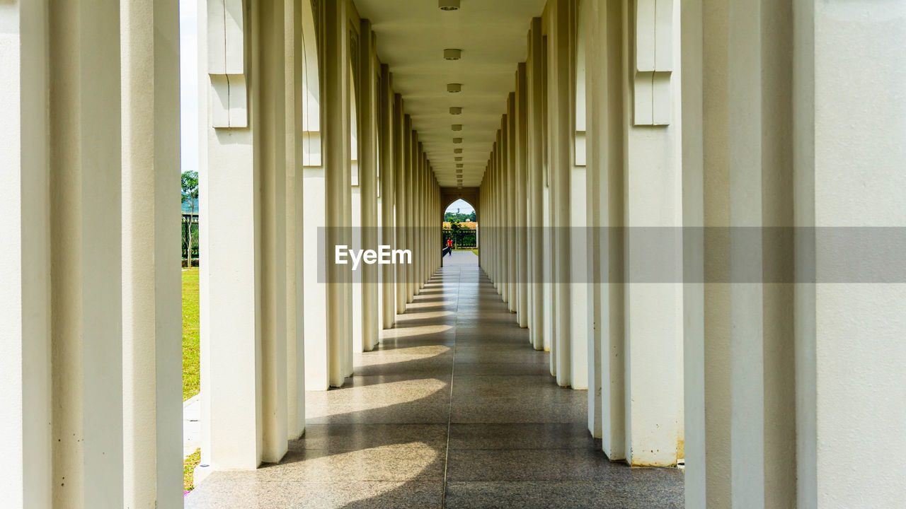 REAR VIEW OF MAN WALKING IN BUILDING