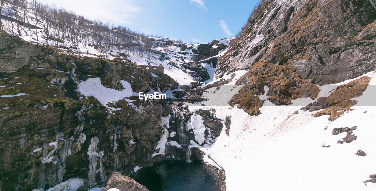 snow, cold temperature, mountain, scenics - nature, winter, environment, beauty in nature, nature, landscape, sky, mountain range, water, travel, travel destinations, rock, adventure, activity, leisure activity, snowcapped mountain, cloud, ridge, hiking, ice, land, sports, outdoors, day, pinaceae, coniferous tree, pine tree, tourism, cirque, mountain peak, tree, non-urban scene, tranquility, forest, glacier, glacial landform, frozen, plant