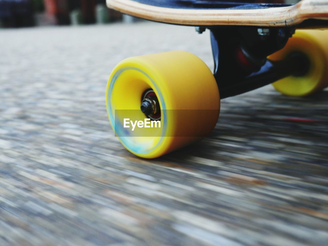 Cropped image of skateboard moving on street
