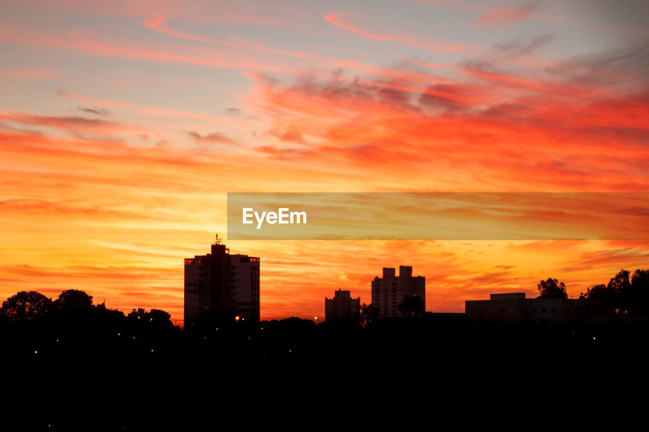 SILHOUETTE BUILDINGS AGAINST DRAMATIC SKY