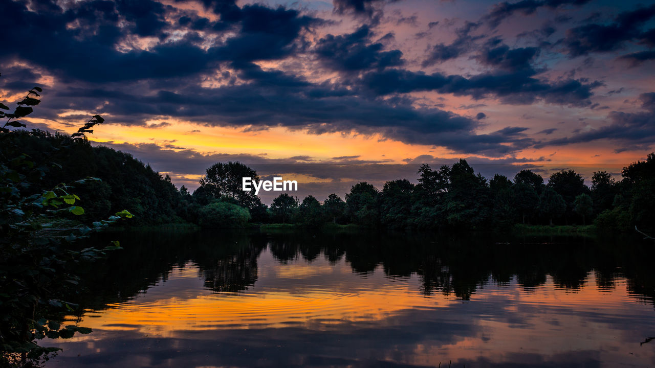 Scenic view of lake against sky at sunset