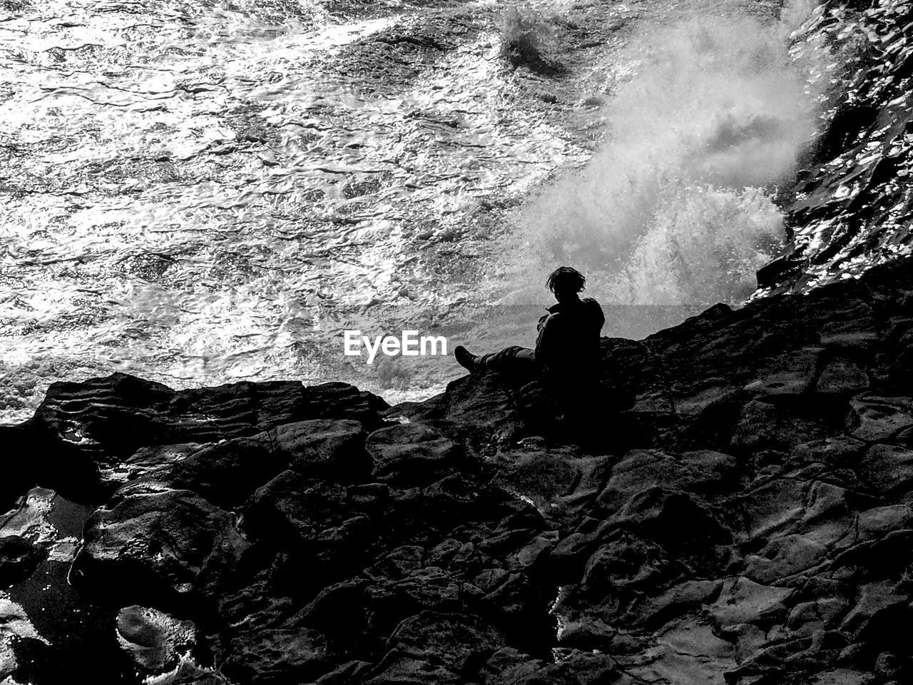 MAN SITTING ON ROCK