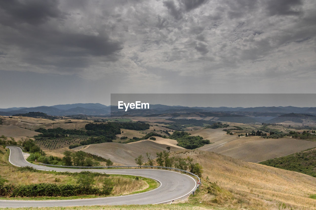 Scenic view of road by mountains against sky