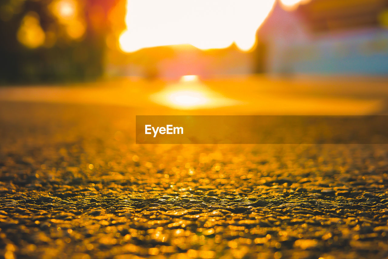 SURFACE LEVEL OF WET ROAD DURING SUNSET