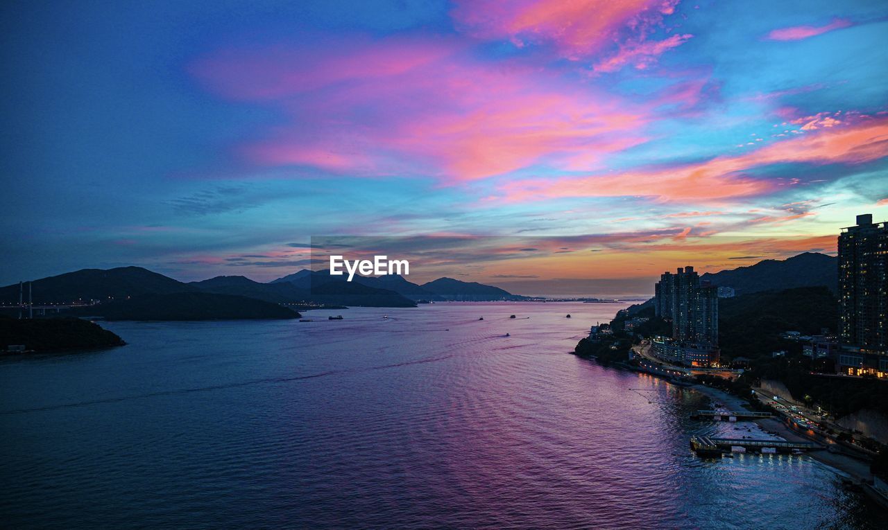 Scenic view of bay against sky at sunset