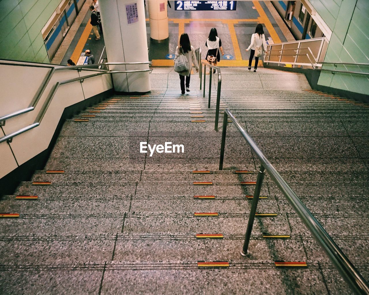 High angle view of women walking on steps at railroad station