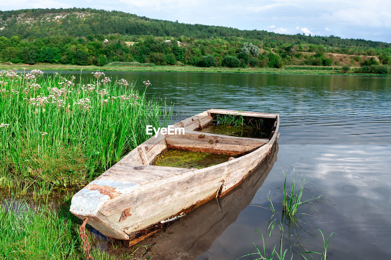 Sunken wooden fisherman boat . old wooden barque . picturesque river nature