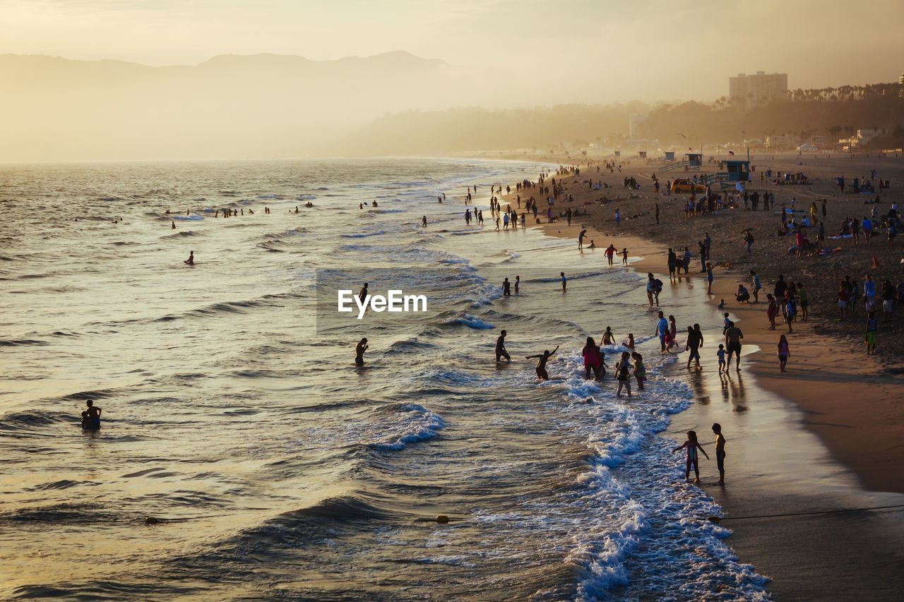 People enjoying summer sunset at beach