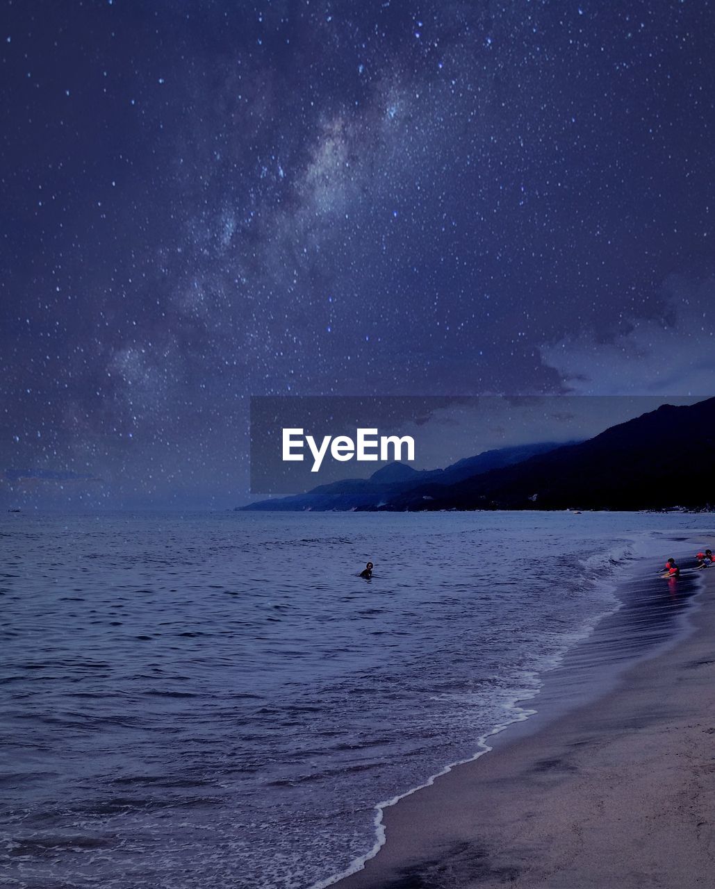 Scenic view of beach against sky at night