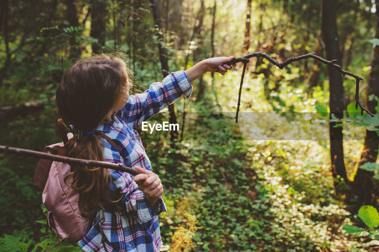 Girl holding sticks at forest