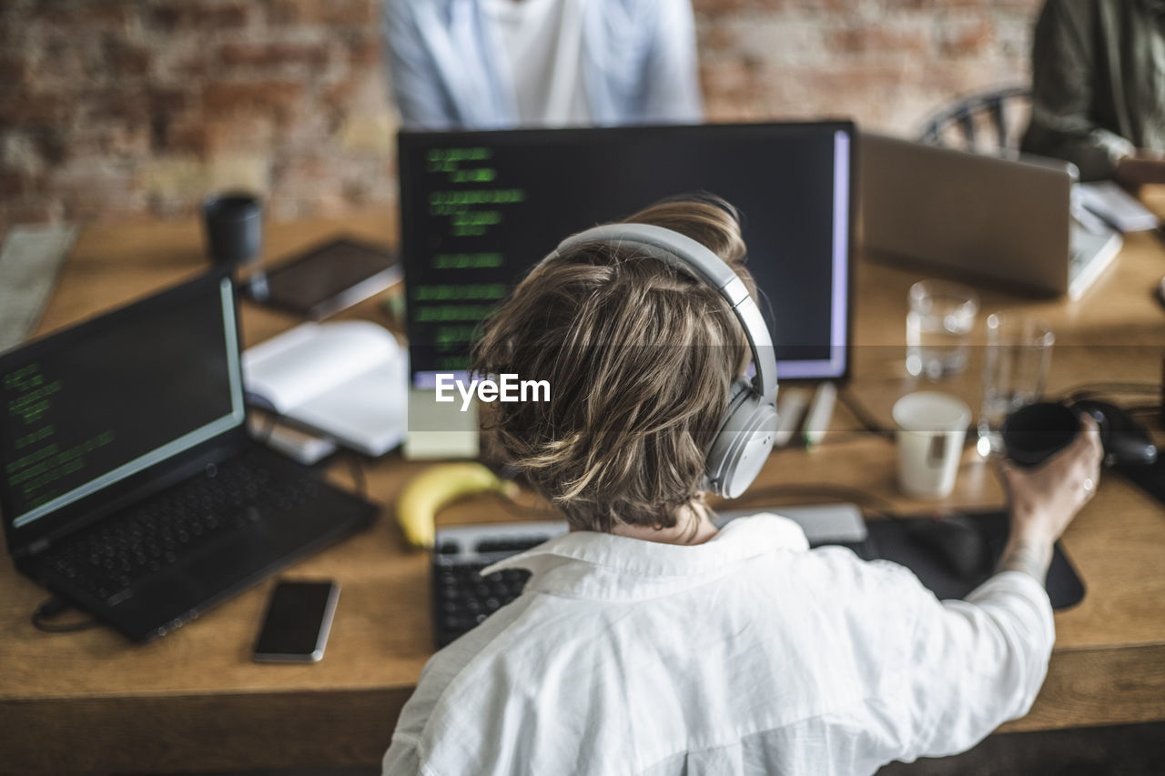 Female hacker working over computer at creative office