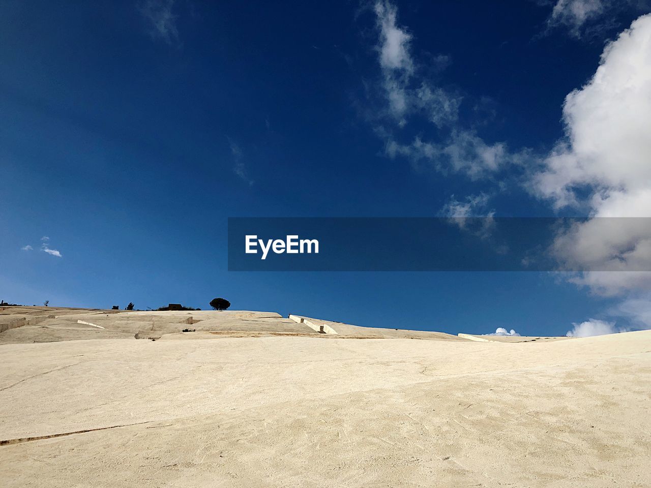 Scenic view of desert against blue sky