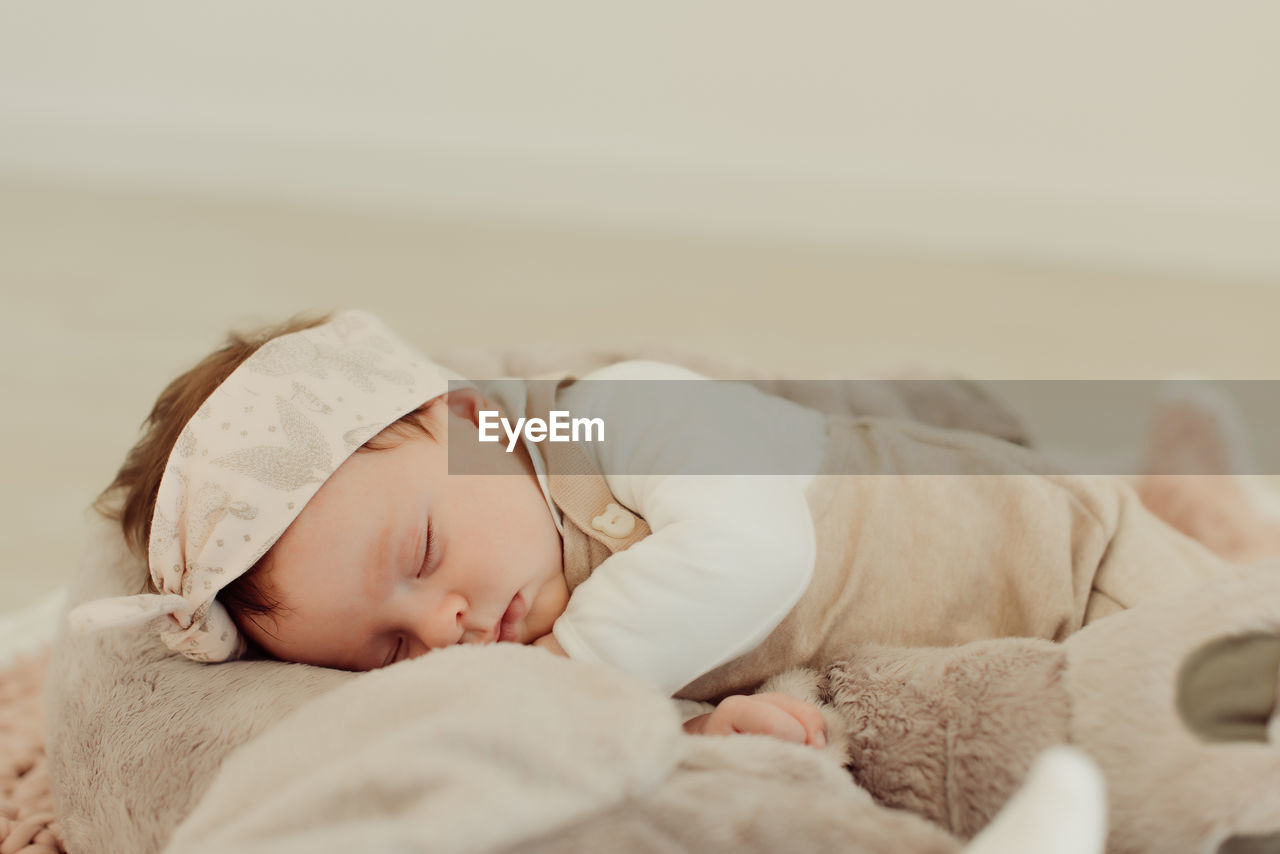 Cute baby girl sleeping on bed at home