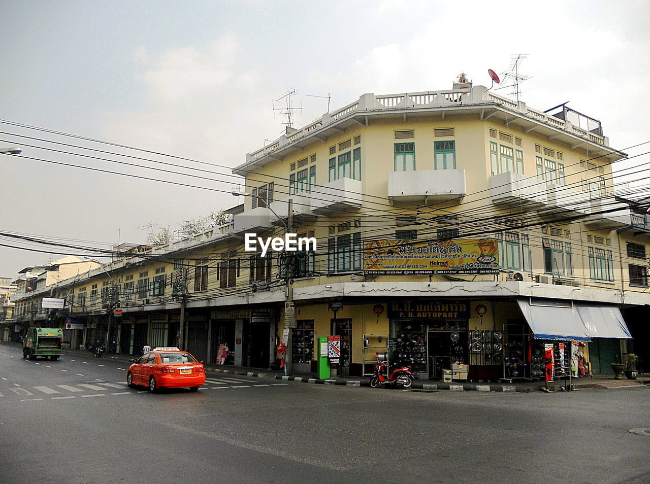 CARS ON STREET BY BUILDING AGAINST SKY