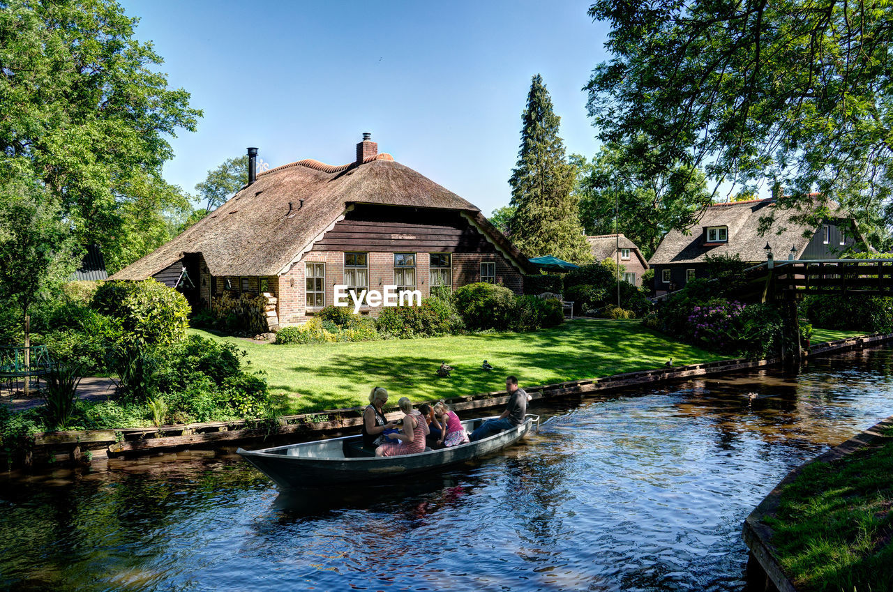 HOUSES BY RIVER AGAINST SKY